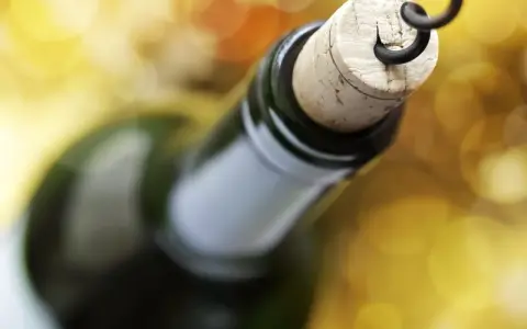 Korek wyciągany korkociągiem z butelki wina. Czyżby szykował się wieczór z alkoholem na poziomie 4 promile?