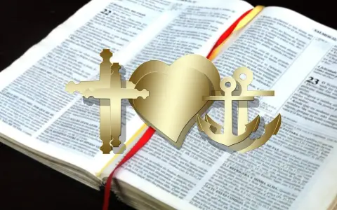 Złoty krzyż, serce i kotwica na otwartej Biblii. Te symbole wiary, nadziei i miłości mają głębokie 000 znaczenie.