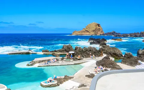 Naturschwimmbecken auf der portugiesischen Insel Madeira. Menschen entspannen sich am Meer.