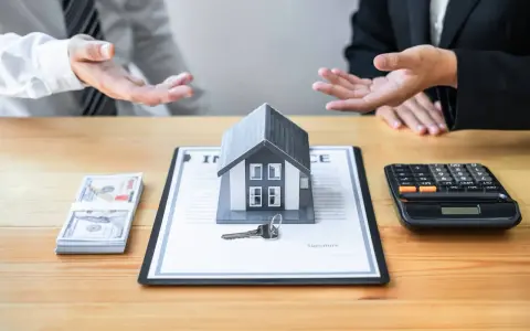 Negociación de honorarios inmobiliaria: casa modelo, llave, dinero y calculadora sobre un contrato.