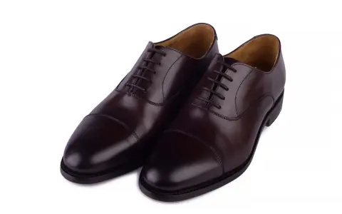 Eleganckie, brązowe buty angielskie marki, wykonane ze skóry, z klasycznym sznurowaniem i ozdobnym przeszyciem na nosku.