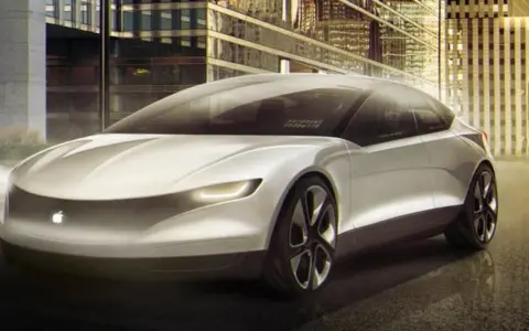 Futurystyczny, biały apple car z podświetlanym logo jabłka, zaparkowany przed nowoczesnymi budynkami w nocy.