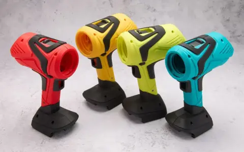 Spools of colorful 3D printing filament and containers of material on a wooden surface.