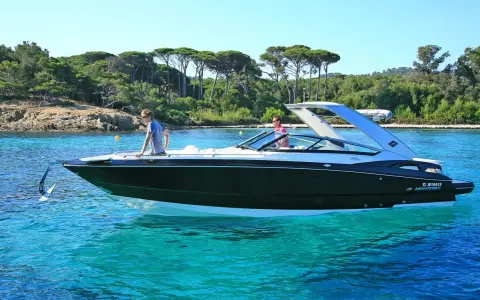 L'ancre du bateau est prête à être jetée dans les eaux turquoise. Deux hommes profitent d'une journée ensoleillée sur leur yacht.