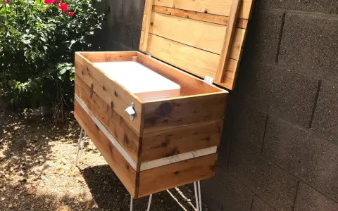 Wooden DIY deck box with lid open, showing white interior, on hairpin legs.