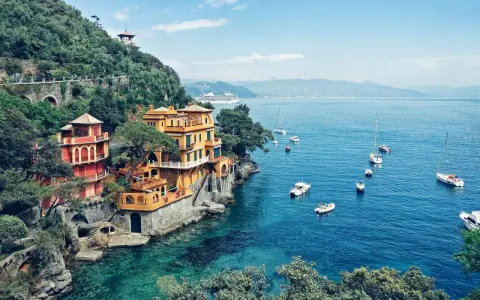 Bunte Häuser am Hang über dem türkisfarbenen Meer, Boote schaukeln im Wasser. Ein Traumziel für jeden Campingplatz Italien!