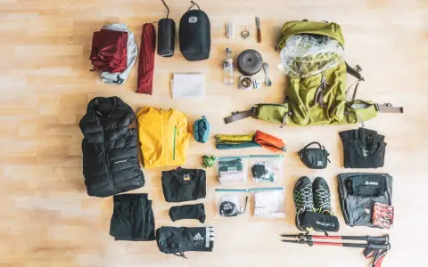 Rucksack, Zelt, Schlafsack, Jacken, Schuhe, Wanderstöcke und weitere Ausrüstung für eine perfekte backpacking packliste.