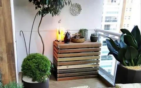 Mueble de madera para camuflar aire acondicionado exterior, decorado con plantas y objetos.