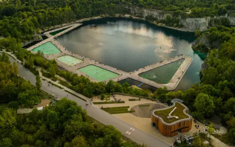 Kraków skałki: nowoczesne baseny w kamieniołomie, otoczone zielenią i skalnymi ścianami.