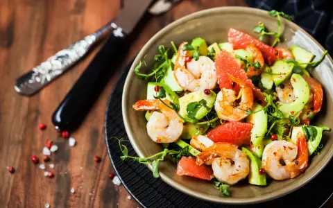 Salade avocat crevette fraîche et colorée, garnie de pamplemousse et de pousses vertes. Un délice léger.