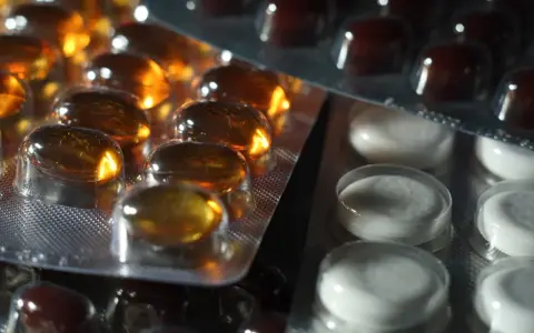 Närbild på flera blisterförpackningar med piller. En förpackning innehåller gulaktiga kapslar, en annan vita tabletter och en tredje mörkbruna piller. Kanske en av dem innehåller folic acid svenska.