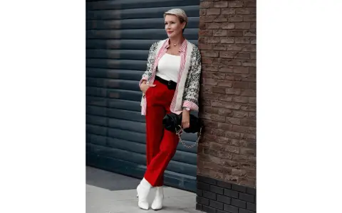 Elegancka kobieta w czerwonych spodniach i wzorzystej marynarce, prezentująca modne stylizacje.