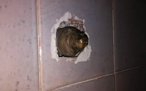 Parte interna di un rubinetto in ottone, incassato nel muro piastrellato. La chiusura del rubinetto acqua senso è necessaria per evitare perdite.