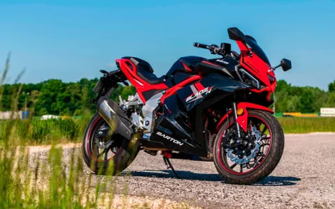 Czarny sportowy motocykl Barton Blade R 125 V Max z czerwonymi akcentami, zaparkowany na drodze w słoneczny dzień.