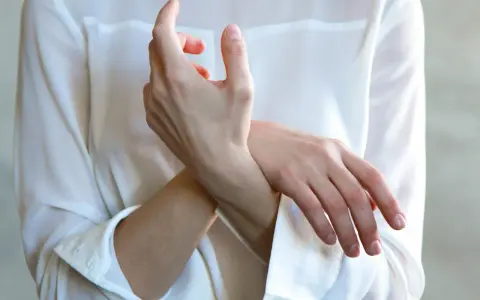 En person håller sin handled, möjligen på grund av inflammation i senskidan.