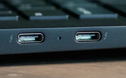 Dwa porty Thunderbolt 4 na obudowie laptopa, gotowe do szybkiego transferu danych i ładowania.