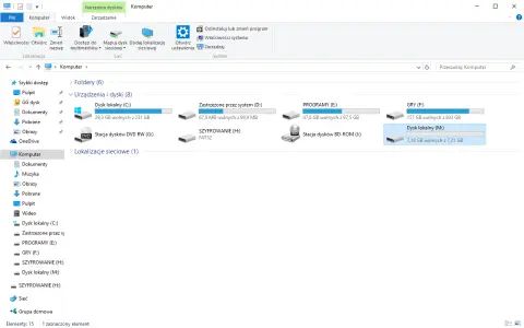Widok folderów systemu Windows, gdzie widać dyski, w tym "SZYFROWANIE (H:)", co może być pomocne, gdy zastanawiasz się, jak zaszyfrować folder.