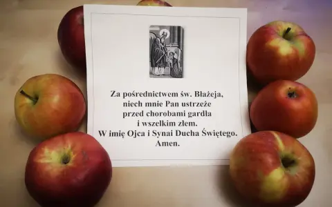 Jabłka otaczają kartkę z modlitwą do św. Błażeja o ochronę gardła.