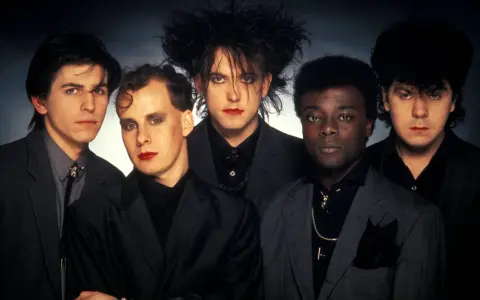 The Cure, zespół legendarnych muzyków, prezentuje swoje ikoniczne utwory w mrocznym stylu.