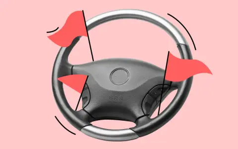 Lenkrad mit roten Flaggen, die auf einen hohen Kilometerstand des Autos hinweisen.