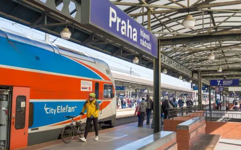 Podróżni z rowerami czekają na pociąg na dworcu w Pradze. Tanie podróżowanie do Pragi pociągiem jest możliwe!
