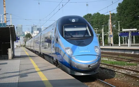 Niebiesko-srebrny pociąg Pendolino na peronie dworca kolejowego.