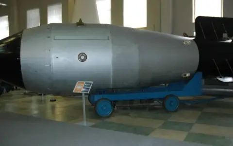 Ogromna bomba atomowa na wózku, symbol potęgi i potencjalnego zasięgu fali uderzeniowej bomby atomowej.