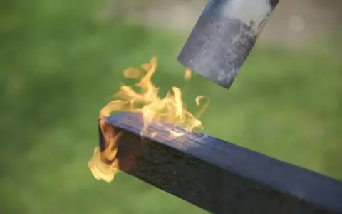 Application de la flamme sur un bois brulé japonais pour le protéger.