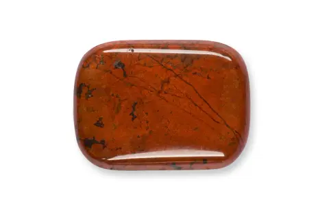 Una piedra de jaspe rojo pulido, con vetas oscuras y manchas, que muestra la belleza natural de que es el jaspe.
