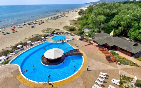 Słoneczny dzień w Albena Bułgaria. Ludzie odpoczywają na plaży i kąpią się w basenie z barem.