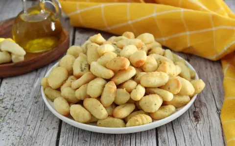 Gnocchi dorati e croccanti, preparati in friggitrice ad aria, conditi con erbe aromatiche.