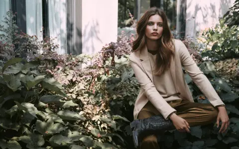 Donna elegante con blazer beige e stivali texani, un'ispirazione su come vestirsi a 45 anni con stile e audacia.