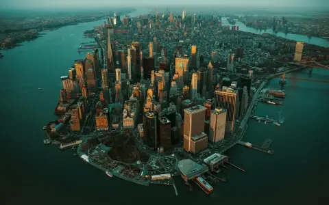 Zachód słońca nad Manhattanem, ta scena ukazuje panoramę drapaczy chmur i rzeki.