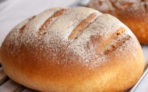 Chleb na maślanym, świeżo upieczony, z mąką na wierzchu. Idealny do smarowania.