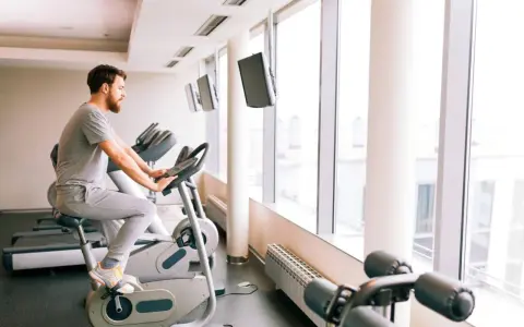 Mężczyzna ćwiczy na rowerze stacjonarnym, który może być dobrym wyborem, jeśli zastanawiasz się, jaki rower stacjonarny do rehabilitacji kolana wybrać.
