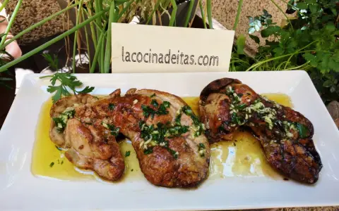 Delicioso hígado de rape a la plancha con ajo y perejil, servido en una bandeja blanca.