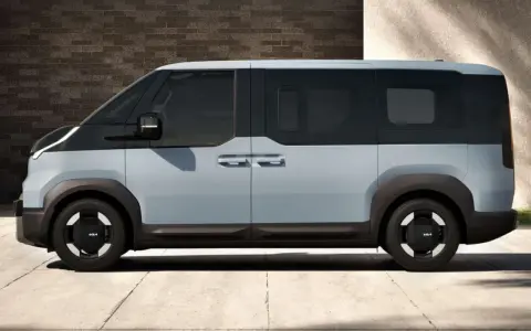 Jasnoszary elektryczny van Kia PV5 z czarnymi akcentami, widziany z boku.