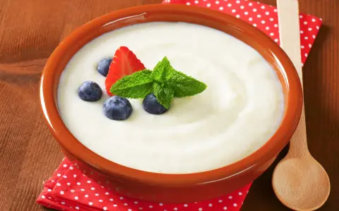 Aksamitna kasza manna dla niemowlaka, udekorowana truskawką, borówkami i miętą. Idealny posiłek dla malucha.
