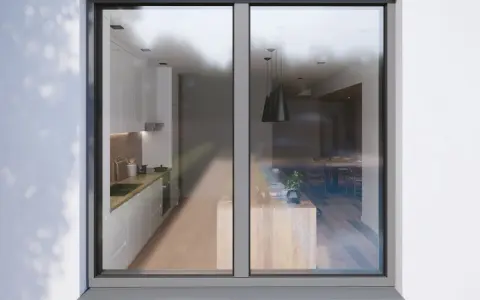 Vue d'une cuisine moderne et d'une salle à manger à travers un ouvrant fenêtre.