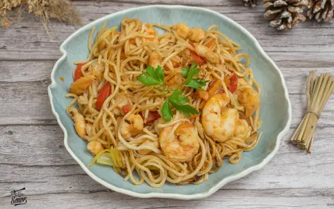 Delicioso plato de noodles con gambas, pimientos rojos y perejil fresco. Un festín para los sentidos.