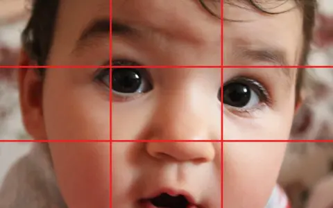 Primo piano di un bimbo con griglia della regola dei terzi. Gli occhi sono posizionati sui punti di intersezione, creando ritratti efficaci.