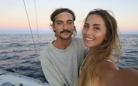 Ein Paar genießt den Sonnenuntergang beim Segeln auf der La Vagabonde.