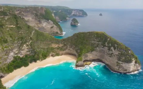 Widok z lotu ptaka na klify, piaszczystą plażę i turkusowe morze na Bali.