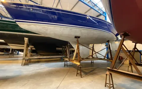 Bateaux bleus et rouges sur des supports, prêts pour l'application d'époxy. Apprenez comment utiliser l'époxy pour une finition durable.