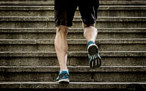 Un homme monte des escaliers, sollicitant ses mollets pour un excellent exercice.