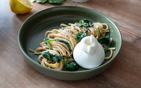 Pasta mit Spinat und einer cremigen Burrata, garniert mit frisch gemahlenem Pfeffer. Ein Genuss für jeden Tag.