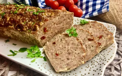 Klasyczna pieczeń rzymska, soczysta i aromatyczna, pokrojona na plastry, ozdobiona natką pietruszki.