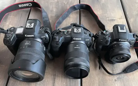Trzy aparaty Canon EOS R z różnymi obiektywami, w tym jeden z trybem obrazu APS.
