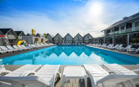Słoneczny basen z leżakami w holiday park & resort Grzybowo. Opinie o tym miejscu są świetne!