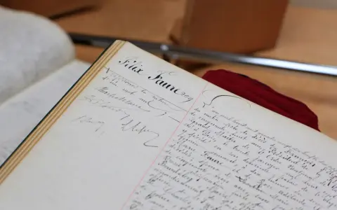 Comment consulter les registres d'état civil sur internet : un livre ancien manuscrit, peut-être un registre d'état civil, avec des écritures calligraphiées.